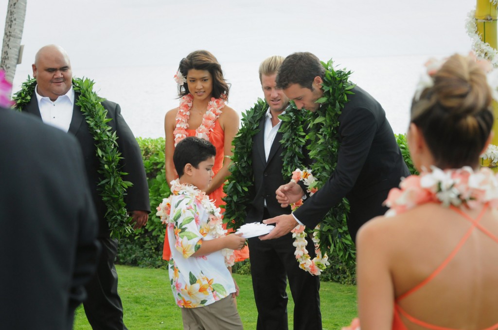 Un jeune garçon remet les alliances à Steve (Alex O'Loughlin) devant Kamekona (Taylor Wily), Kono (Grace Park) et Danny (Scott Caan).
