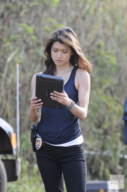 Kono Kalakaua (Grace Park) regarde sa tablette qu'elle tient entre ses mains.