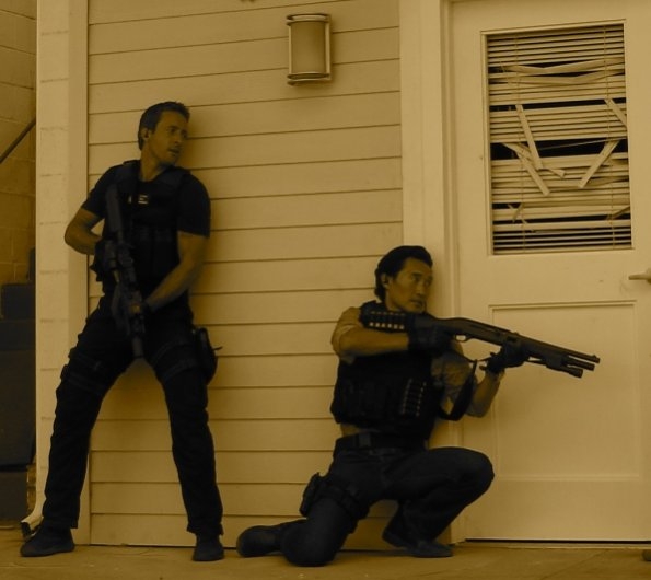 Chin (Daniel Dae Kim) s'apprête à défoncer la porte en utilisant son fusil à pompe. Il est accompagné de Steve McGarrett (Alex O'Loughlin) qui est également armé.