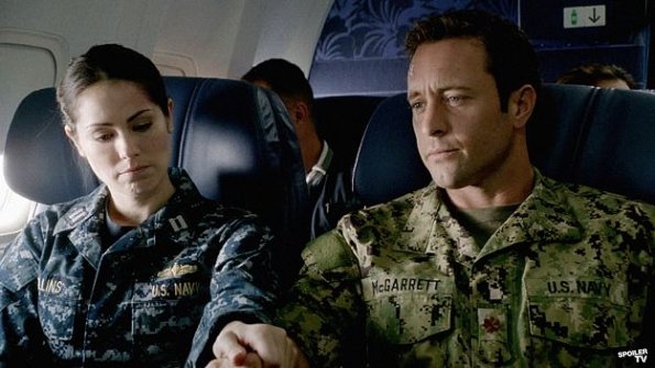 En tenue de militaire, Catherine (Michelle Borth) et Steve (Alex O'Loughlin) se trouvent dans un avion.
