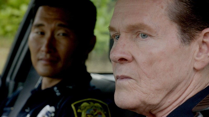 John (William Sadler) se trouve dans sa voiture de police avec Chin (Daniel Dae Kim).