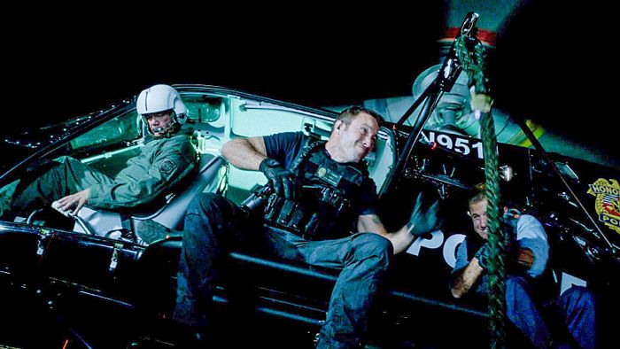 Steve (Alex O'Loughlin) et Danny (Scott Caan) se trouvent dans un hélicoptère et tirent sur des ennemis.