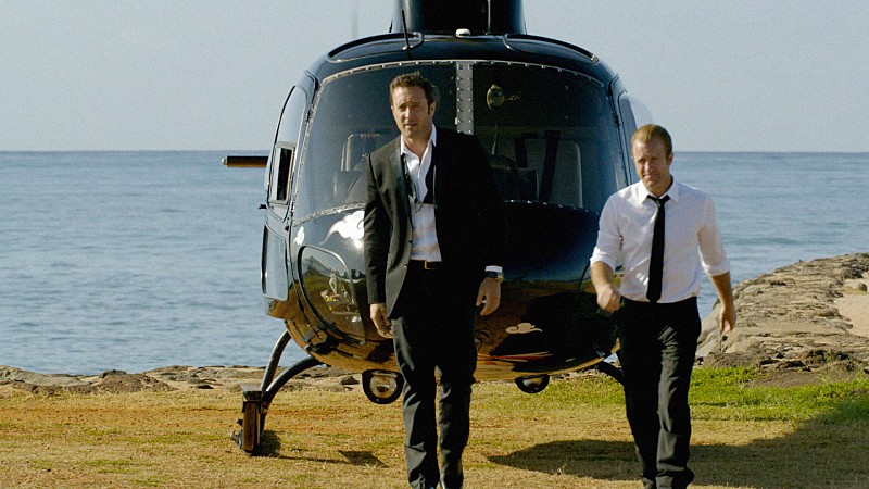 Steve (Alex O'Loughlin) et Danny (Scott Caan) marchent devant un hélicoptère.