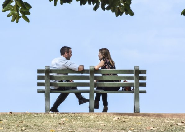 Steve McGarrett (Alex O'Loughlin) discute avec Alicia Brown (Claire Forlani) sur un banc.