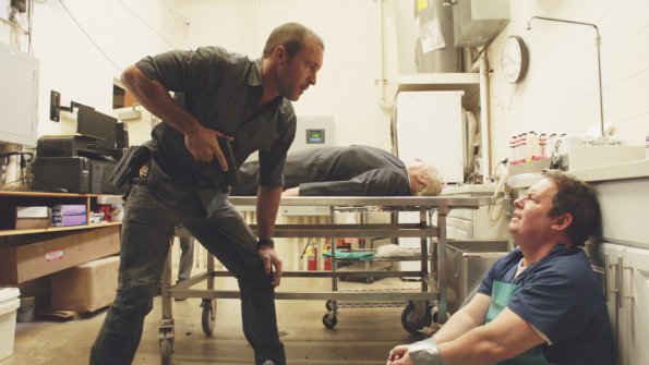 Dans une morgue, Steve McGarrett (Alex O'Loughlin) découvre le médecin légiste avec les mains ligotés.