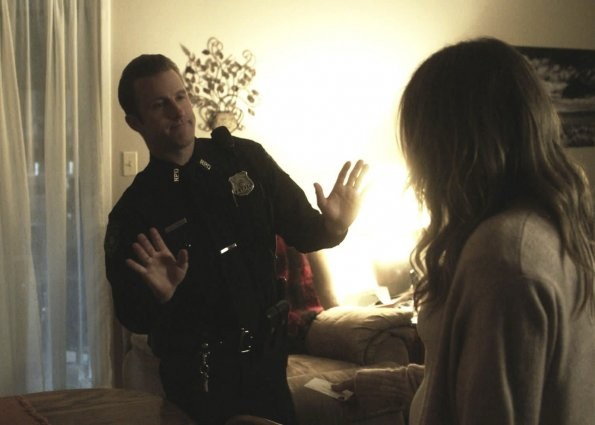 En uniforme de police du New Jersey, Danny semble refuser ce que lui tend Brooke Gardner.