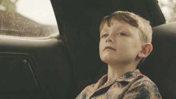 Le jeune Steve McGarrett qui est joué par Victor Williams patiente à l'arrière d'une voiture...