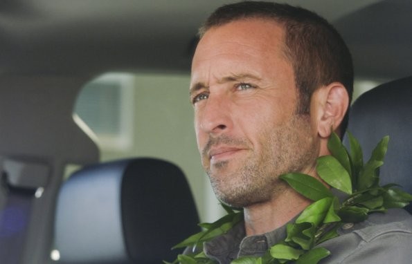 Steve McGarrett (Alex O'Loughlin) se trouve à l'intérieur de sa voiture avec un collier de fleurs autour de son cou et semble regarder quelque chose...