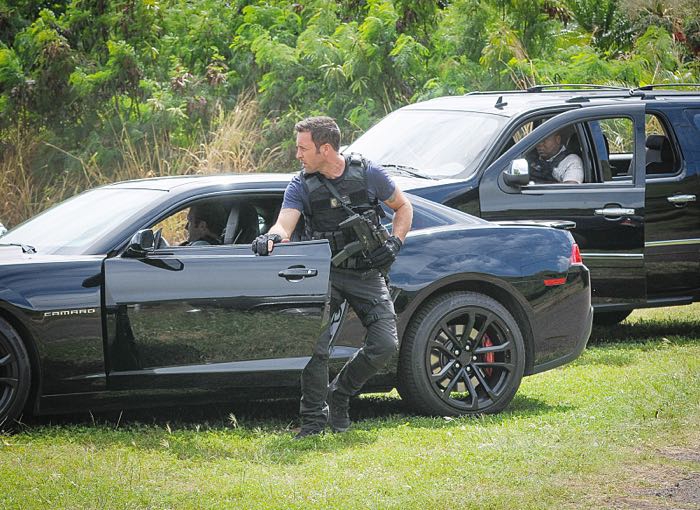 McGarrett (Alex O'Loughlin) sort de la voiture avec son arme.