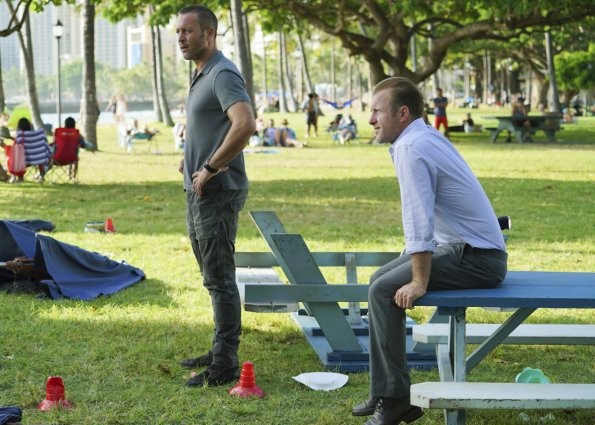 Danny (Scott Caan) est assis sur l'une des tables du camion tandis que Steve (Alex O'Loughlin) est debout à côté de son partenaire.