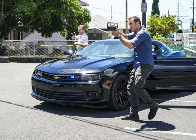 McGarrett (Alex O'Loughlin) et Danny (Scott Caan) sortent de leur voiture en pointant leurs armes sur une personne.