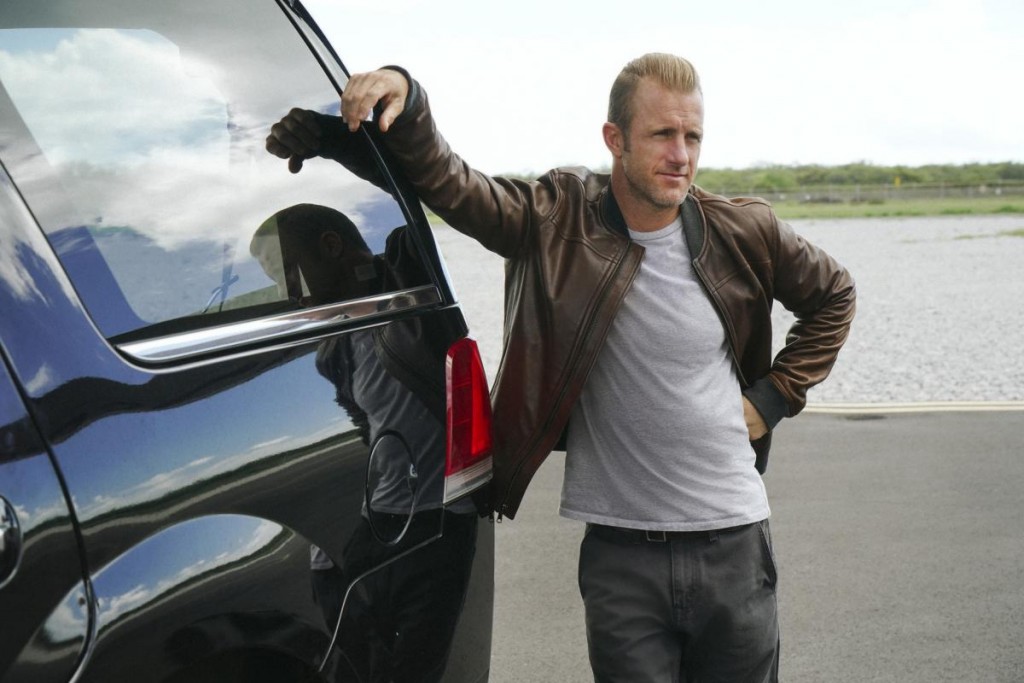 Danny (Scott Caan) patiente en appuyant son bras contre la voiture.