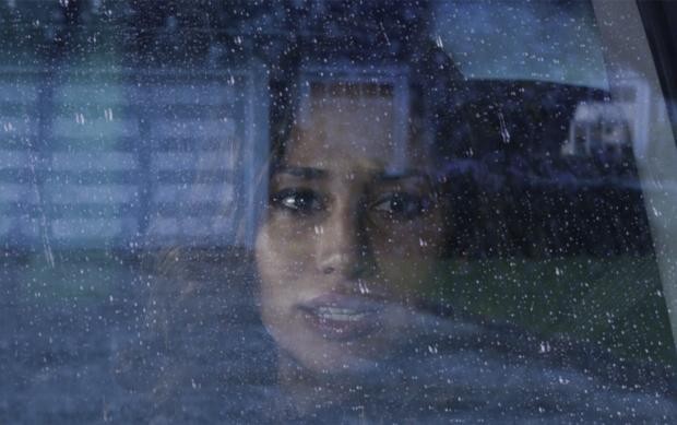 Tani (Meaghan Rath) observe quelque chose par la vitre de sa voiture...