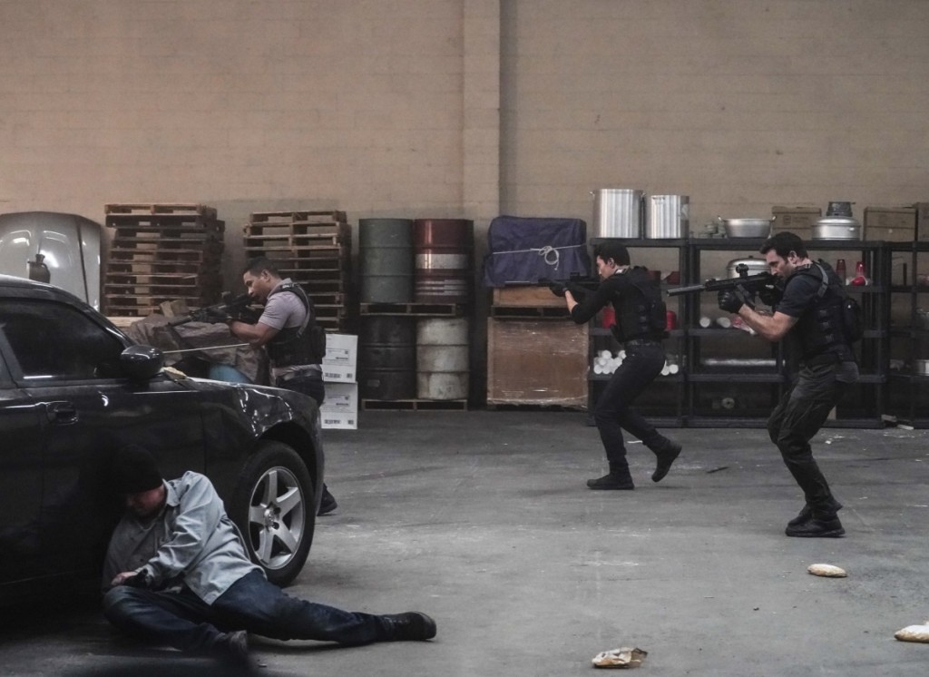 Junior (Beulah Koale), Adam (Ian Anthony Dale) et Steve (Alex O'Loughlin) avancent l'un derrière l'autre. Ils sont armés.