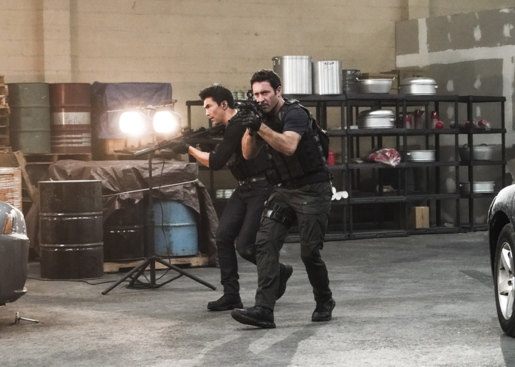 Adam (Ian Anthony Dale) et Steve (Alex O'Loughlin) utilisent leurs armes sur le terrain.