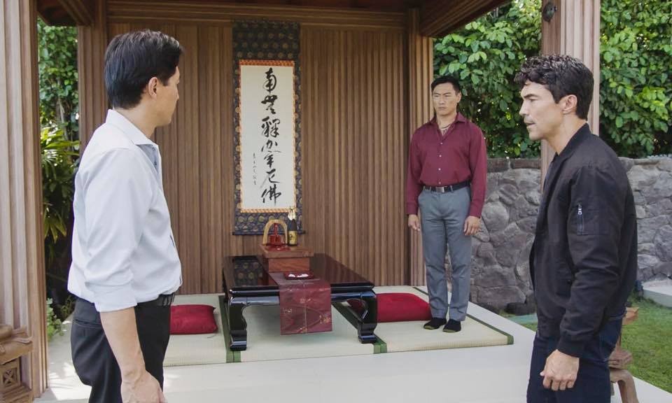 Adam (Ian Anthony Dale) discute avec Masuda (Sonny Saito) sous le regard de Kenji (Fernando Chien).