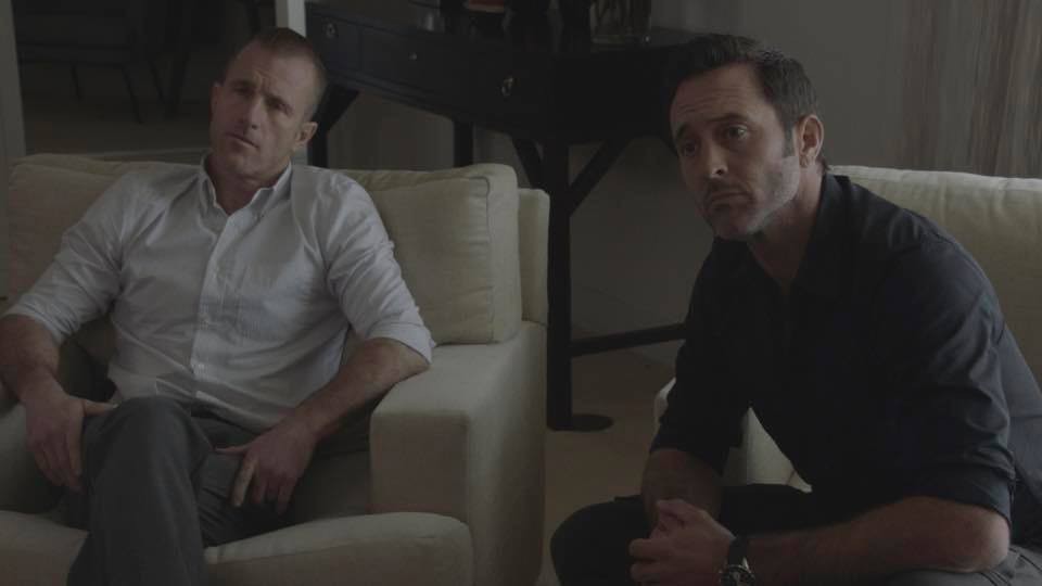 Danny (Scott Caan) et Steve (Alex O'Loughlin) sont assis dans des fauteuils et écoutent attentivement une personne.
