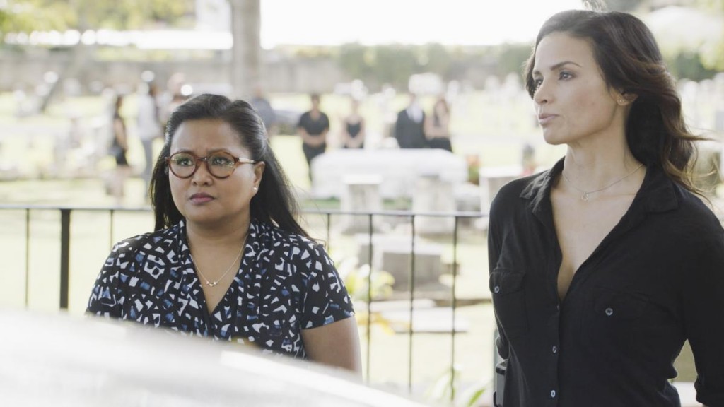 Noelani (Kimee Balmilero) et Quinn (Katrina Law) interrogent un homme devant un cimetière.