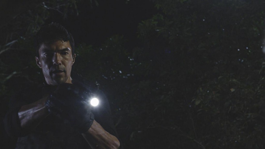 En pleine nuit, Adam (Ian Anthony Dale) tient une arme entre ses mains.