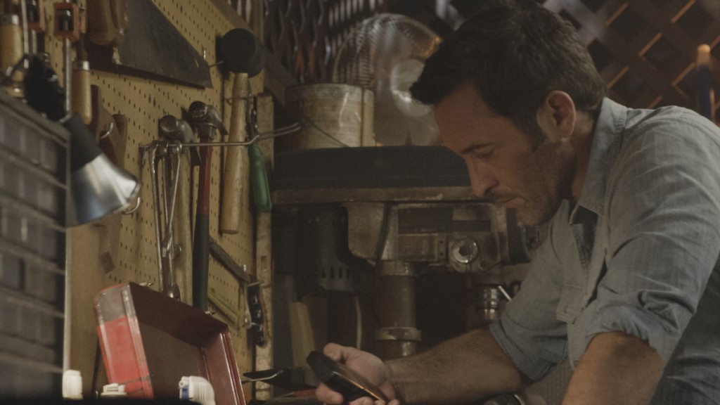 McGarrett (Alex O'Loughlin) se trouve devant la boîte à outils de son père et tient l'enregistreur dans sa main.