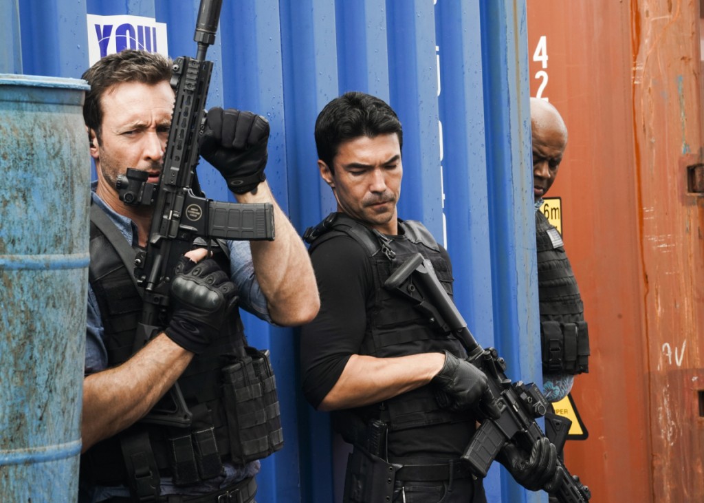 Steve (Alex O'Loughlin) recharge son arme tandis qu'Adam (Ian Anthony Dale) se tient prêt à agir.